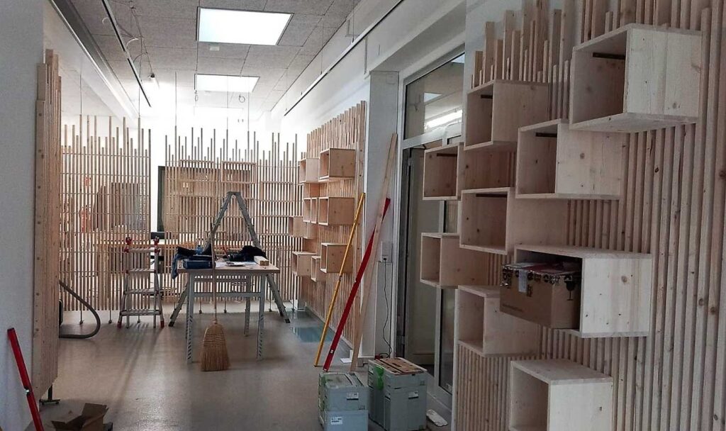 Der erweiterte Bereich des Ladens: Abtrennungswand zum Werkatelier sowie rechts eines der Wandelemente mit Ausstellungsboxen für die Produkte.