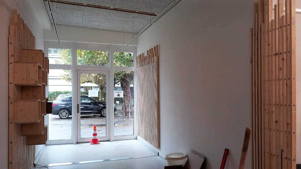 Blick in den Eingangsbereich des LADE15 mit den Wandelementen aus Holzlamellen.